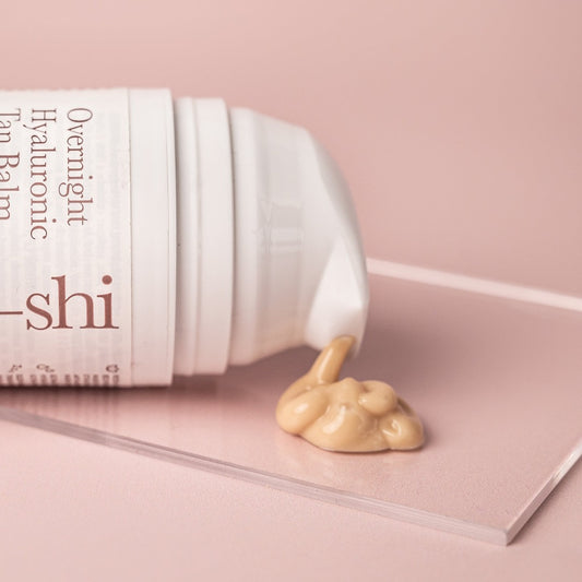 Image of He-Shi Overnight Hyaluronic Tan Balm on its side with product spilling out onto a glass plinth.