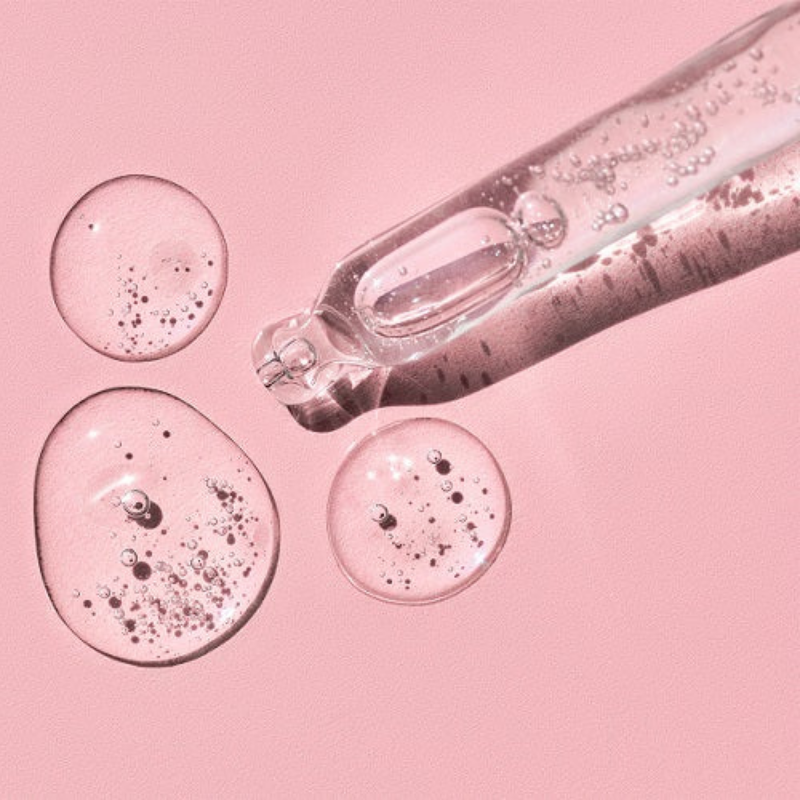 Image of pipette dropping a gel-like skincare onto a pink background. The image demonstrates science in skincare