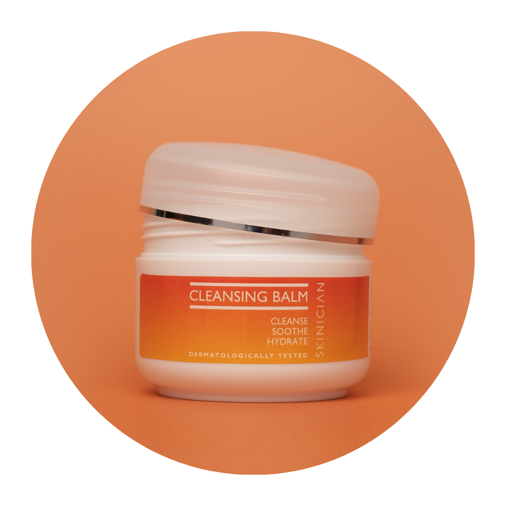 Round image of Skinician Cleansing Balm tub with the lid unscrewed and resting on top of the tub on an orange background