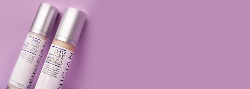 Image of two bottles of Skinician Retinol Powerbalm leaning against a purple background
