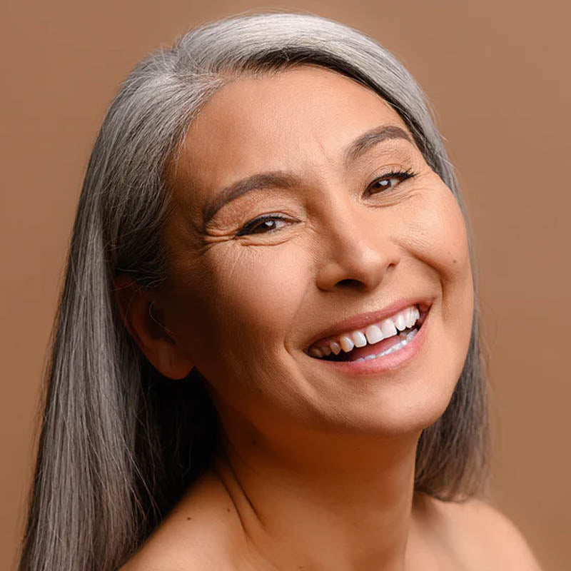Image of middle-aged woman with grey hair smiling