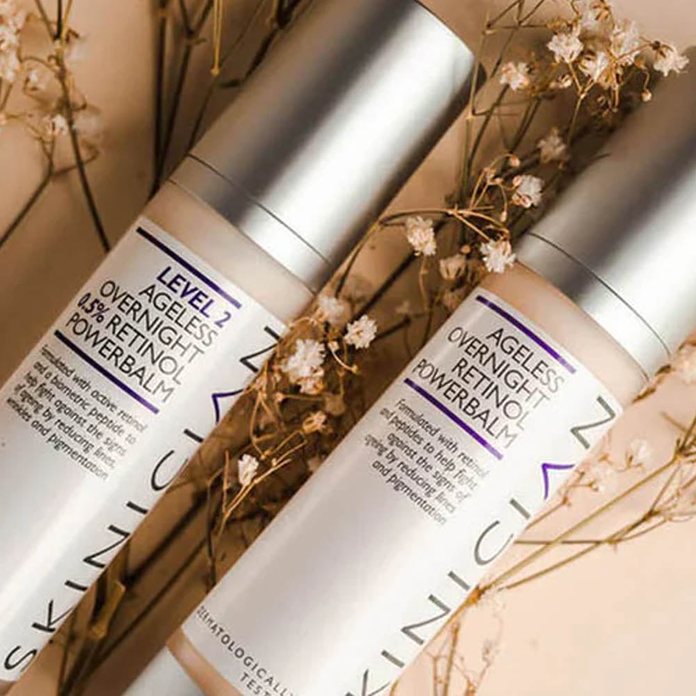 Image of two bottles of Skinician Overnight Retinol Powerbalm lying on flowers