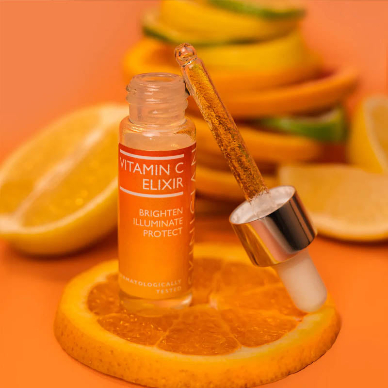 Image of Skinician Vitamin C Elixir placed on top of sliced citrus fruit and on an orange background