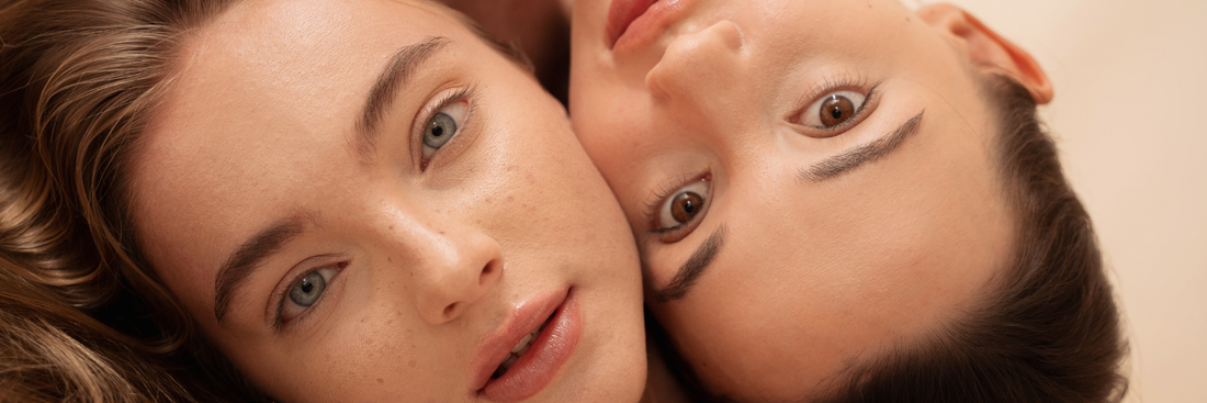 Image of two women, a close-up of their faces lying side by side against a cream background