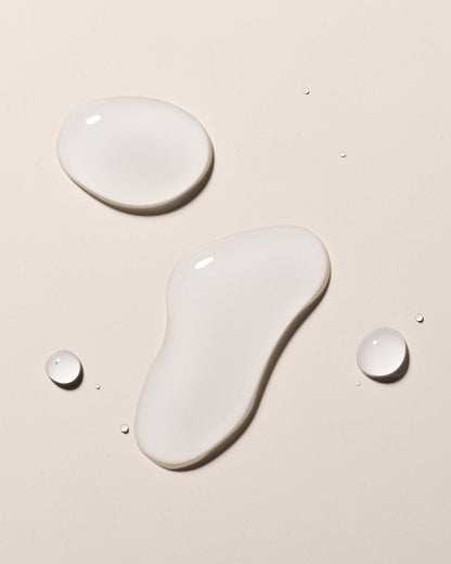 Image of hyaluronic elixir droplets on a beige surface