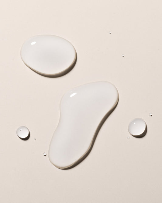 Image of hyaluronic elixir droplets on a beige surface