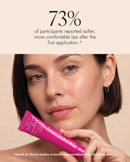 An image of a woman holding a tube of Skinician SPF 50+ Tinted Lip Balm against a warm beige background, with text above stating 73% of participants reported softer, more comfortable lips after the first applicaton.