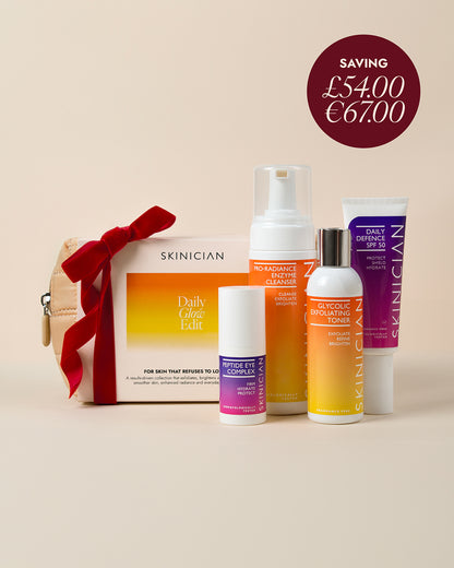 Skinician Daily Glow Edit skincare gift set on a warm beige background with a red ribbon. Image features a dark red circular price tag overlay in the top right that reads "Saving £54 / €67