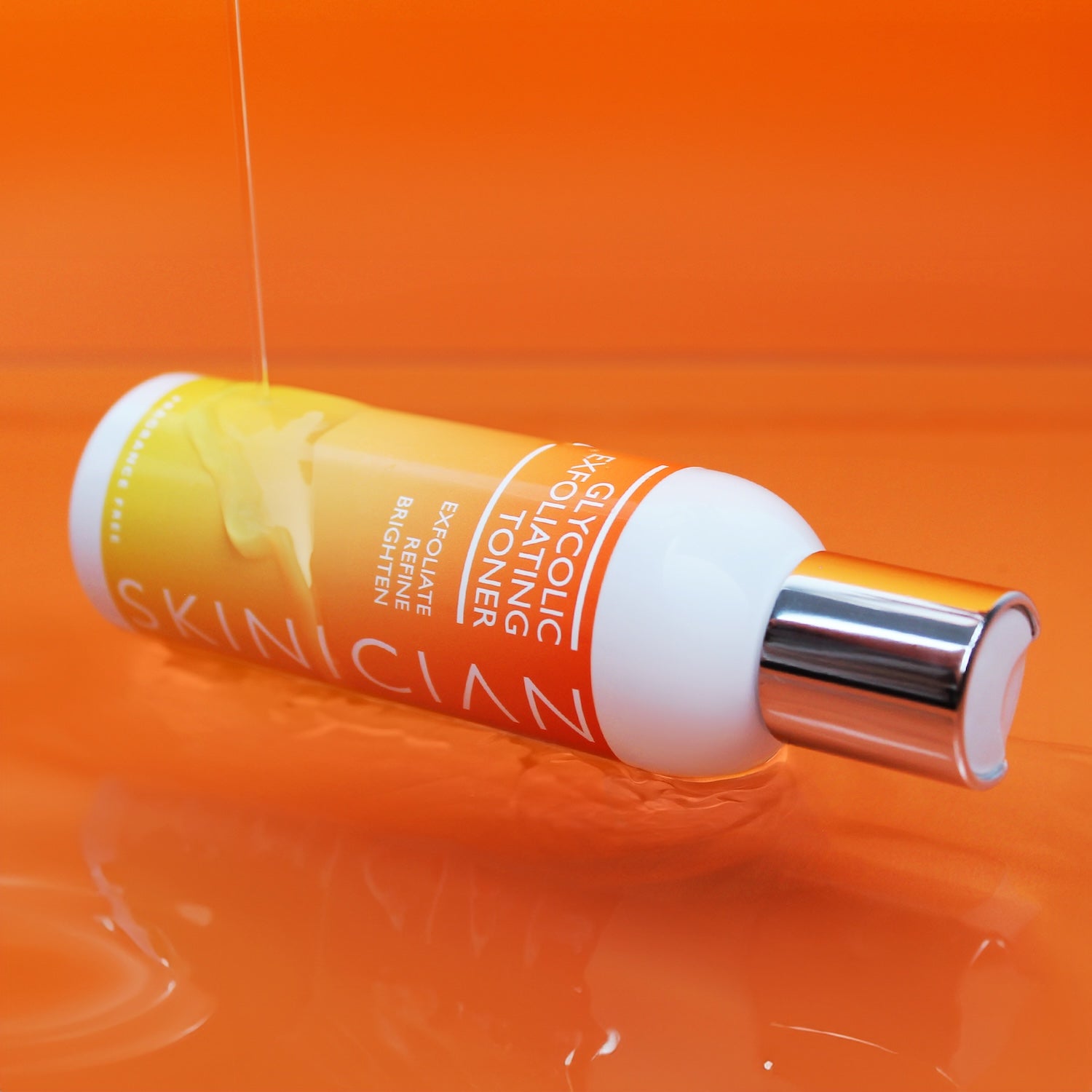 Image of Glycolic Exfoliating Toner laying on its side in a pool of water