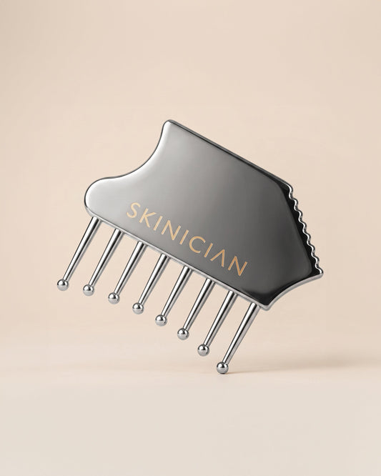 Image of Skinician Gua Sha comb on beige background.