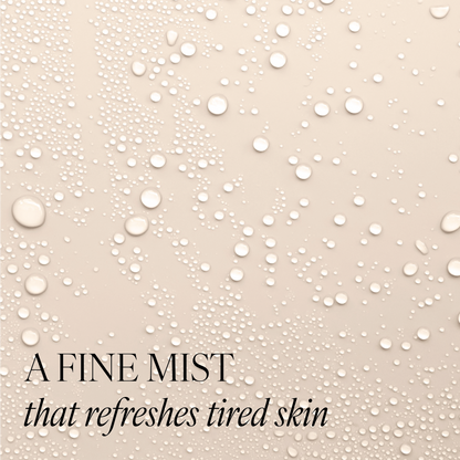 Beige background with water droplets to represent the texture of Revitalising Toner. Image features text "a fine mist that refreshes tired skin"