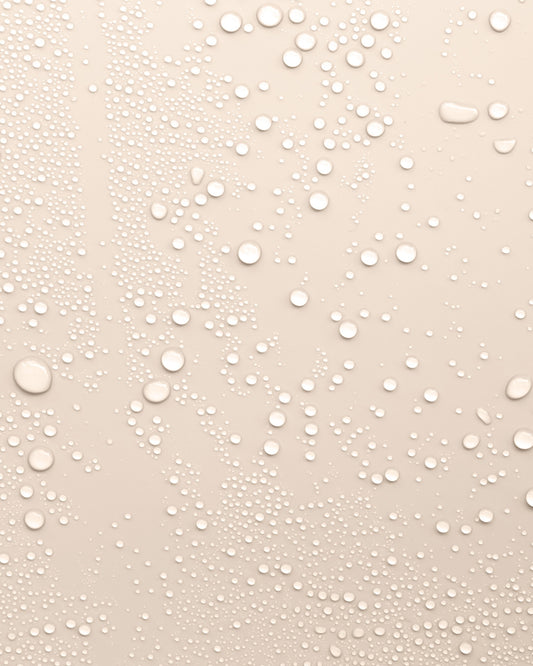 Beige background with water droplets to represent the texture of Revitalising Toner