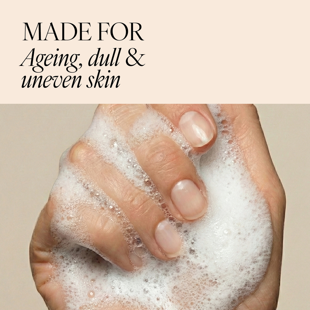 A close-up of a hand covered in white foam, with text at the top reading 'MADE FOR Ageing, dull & uneven skin' on a beige background.