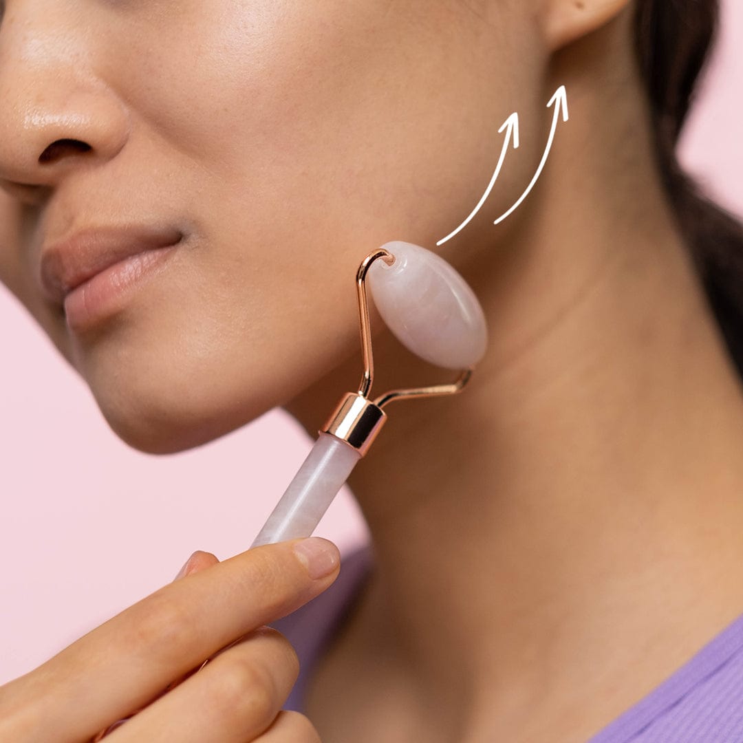 Image of a ladies jaw line with arrows on where to use the rose quartz roller.