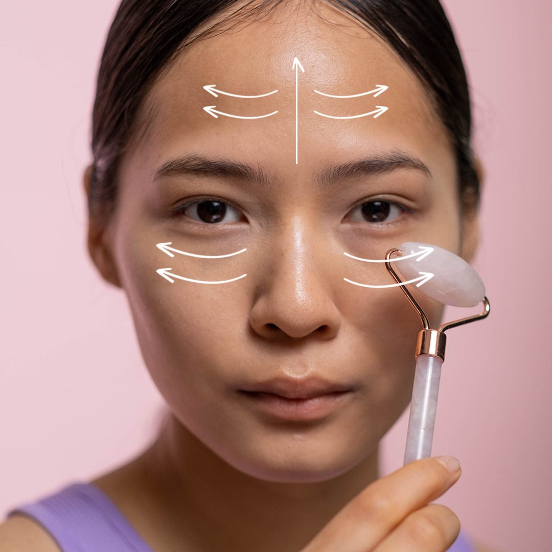 Ladies face with arrows overlayed showing which direction to and how to use the rose quartz roller.