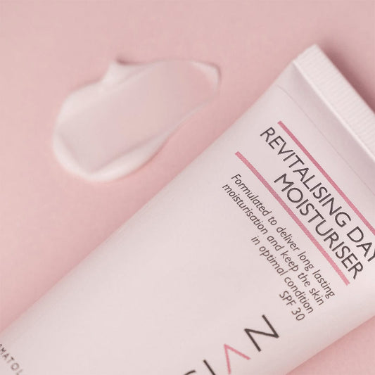 SKINICIAN Revitalising SPF 30 Moisturiser for sensitive and dry skin tube lying on its side with the texture of the cream shown beside it