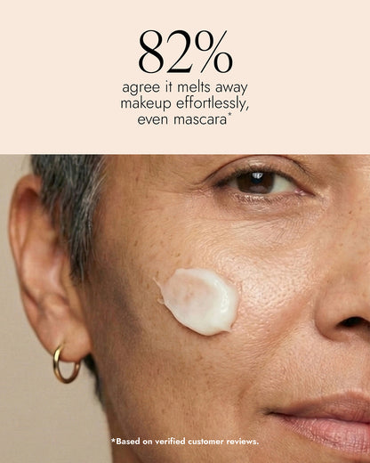 Close-up of a person's face with Cleansing Balm swiped across the cheek. Image features text that reads "82% agree it melts away makeup effortlessly, even mascara"