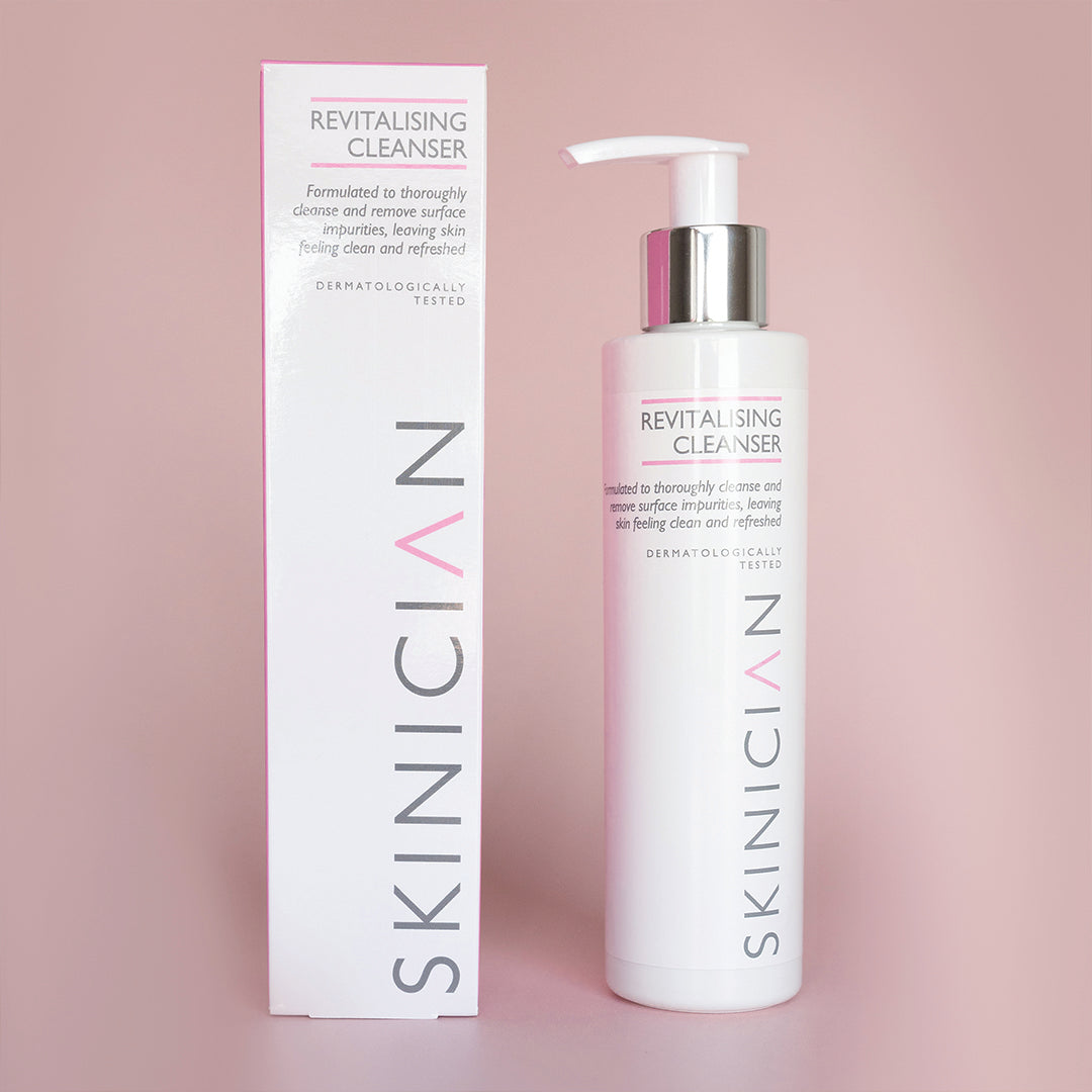 Revitalising cleanser with grapeseed, bottle and box on a pink background.