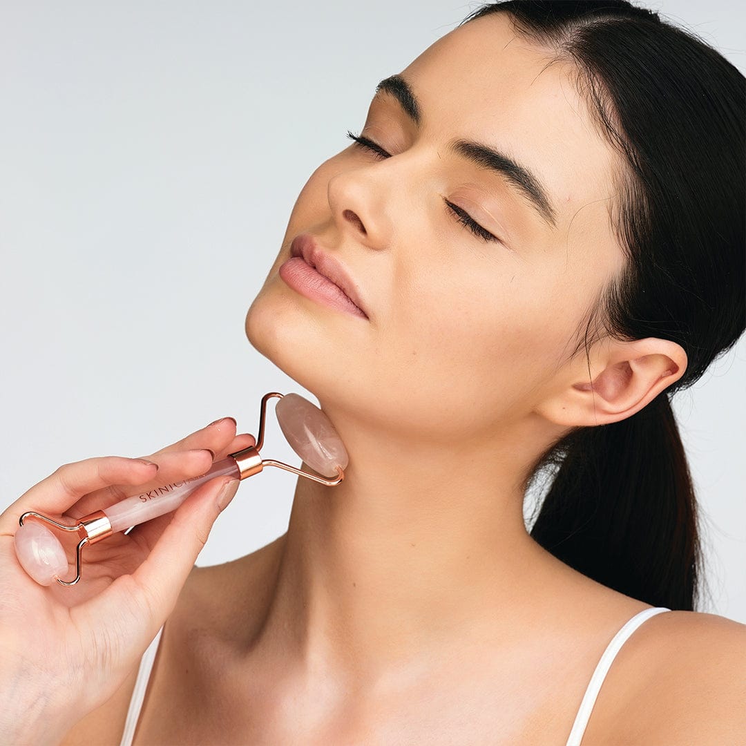 Lady using the rose quartz massage roller on her neck.