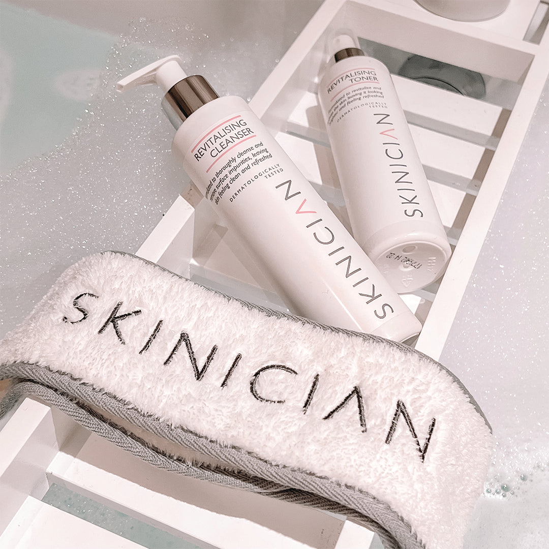 SKINICIAN products on a bathroom rack, including a skincare headband, Revitalising Cleanser and Revitalising Toner